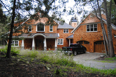 Foto de fachada de casa clásica grande de dos plantas con revestimiento de madera, tejado a dos aguas y tejado de metal