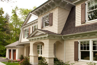Imagen de fachada beige tradicional de tamaño medio de dos plantas con revestimiento de madera y tejado a doble faldón