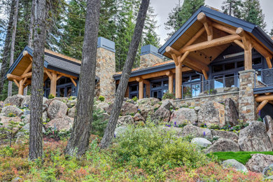 Example of a large mountain style two-story stone exterior home design in Boise with a mixed material roof