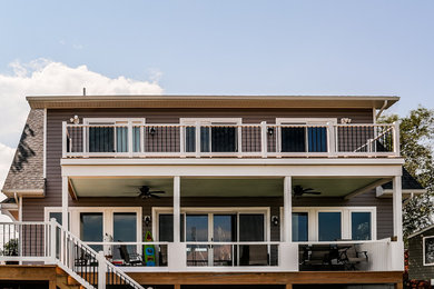 Imagen de fachada de casa gris clásica de tamaño medio de dos plantas con revestimiento de vinilo y tejado de teja de madera