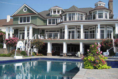 Example of a classic green three-story wood exterior home design in New York