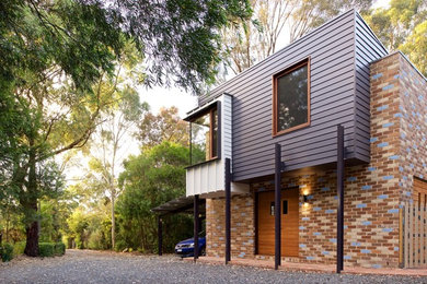 Ispirazione per la facciata di una casa moderna con rivestimento in mattone verniciato