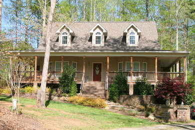 Imagen de fachada beige de estilo de casa de campo grande de dos plantas con revestimiento de vinilo y tejado a dos aguas