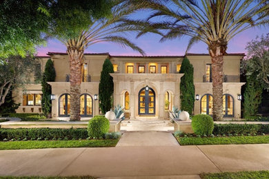 Huge modern beige two-story stucco house exterior idea in Orange County with a tile roof