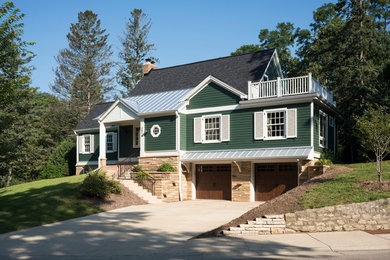 Inspiration for a timeless green two-story metal exterior home remodel in Other with a mixed material roof and a black roof