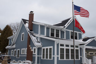 Exemple d'une façade de maison bleue chic en bois de taille moyenne et à un étage avec un toit à deux pans.