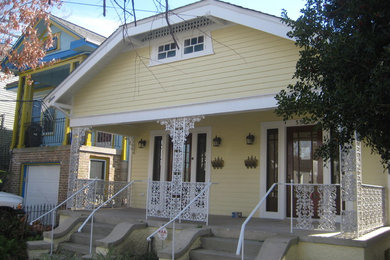 Foto de fachada de casa bifamiliar amarilla ecléctica de tamaño medio de una planta con revestimiento de madera, tejado a dos aguas y tejado de teja de madera