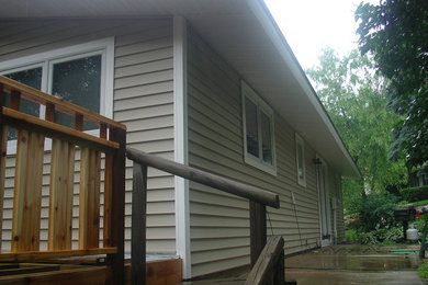 Diseño de fachada de casa marrón de tamaño medio de una planta con revestimiento de vinilo, tejado a dos aguas y tejado de teja de madera