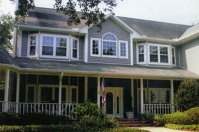 Diseño de fachada de casa gris clásica de tamaño medio de dos plantas con revestimiento de vinilo, tejado a cuatro aguas y tejado de teja de madera