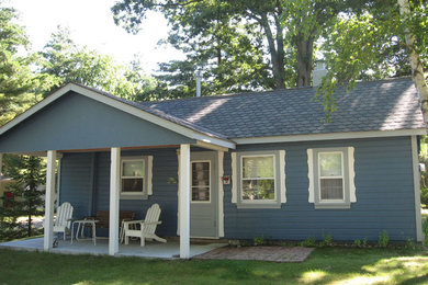Aménagement d'une petite façade de maison bleue de plain-pied avec un revêtement en vinyle.