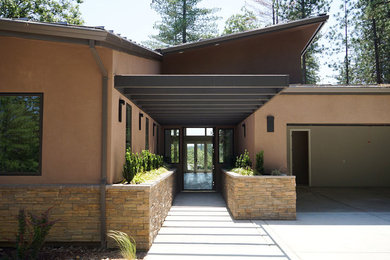 Foto de fachada de casa marrón actual de tamaño medio de una planta con revestimiento de piedra y tejado de metal