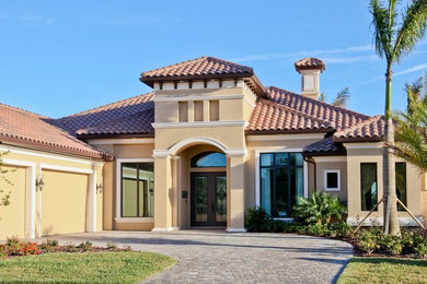 Large tuscan beige one-story stucco house exterior photo in Orlando