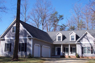 Foto de fachada de casa gris clásica de dos plantas con revestimiento de vinilo y tejado de teja de madera