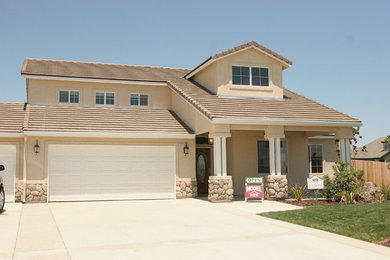 Example of a large classic beige two-story stucco exterior home design in Other with a hip roof