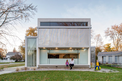 Diseño de fachada de casa gris moderna de dos plantas con tejado plano y revestimientos combinados