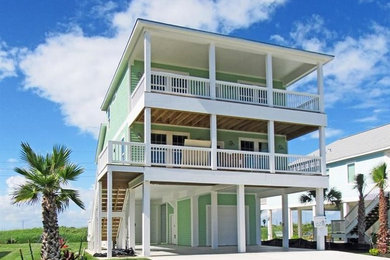 На фото: двухэтажный, зеленый дом в морском стиле с