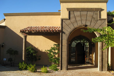 Foto de fachada de casa marrón mediterránea grande de una planta con revestimiento de estuco, tejado plano y tejado de teja de barro