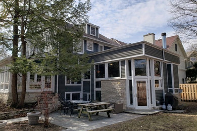 На фото: одноэтажный, деревянный, синий частный загородный дом среднего размера в современном стиле с плоской крышей и крышей из смешанных материалов с