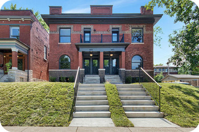 Ejemplo de fachada de casa bifamiliar roja clásica de tamaño medio de dos plantas con revestimiento de ladrillo y tejado plano