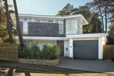 Trendy gray brick exterior home photo in Dorset