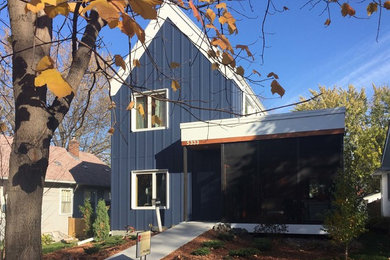 Immagine della villa blu country a due piani di medie dimensioni con rivestimento con lastre in cemento, tetto a capanna e copertura in metallo o lamiera