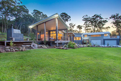 This is an example of a large and gey contemporary two floor concrete house exterior in Sydney with a pitched roof.