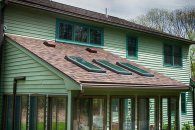Diseño de fachada de casa verde clásica de tamaño medio de dos plantas con revestimiento de madera y tejado de teja de madera