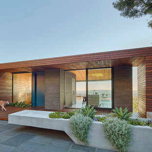 Diseño de fachada marrón, moderna, grande, de una planta, con revestimiento de madera y tejado plano