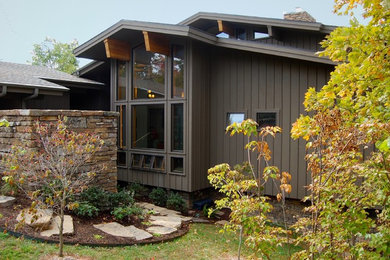 Foto de fachada marrón minimalista grande de dos plantas con revestimiento de madera y tejado a dos aguas