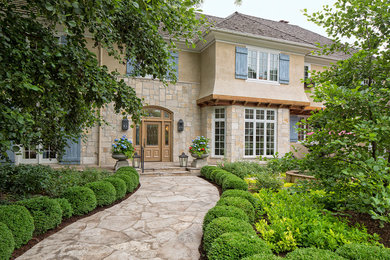 Foto de fachada de casa beige clásica grande de dos plantas con revestimientos combinados, tejado a cuatro aguas y tejado de teja de madera