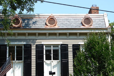 Example of a small classic beige one-story wood house exterior design in DC Metro with a tile roof
