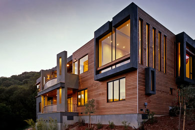 На фото: трехэтажный, деревянный, коричневый дом среднего размера в стиле модернизм с плоской крышей с