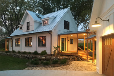 Small country white two-story concrete fiberboard exterior home idea in Milwaukee with a metal roof
