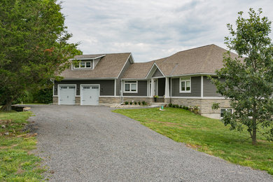 Ejemplo de fachada de casa gris de estilo americano de tamaño medio de una planta con revestimiento de vinilo, tejado a dos aguas y tejado de teja de madera