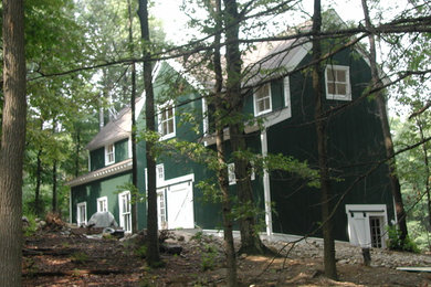 Cette image montre une grande façade de maison verte rustique en bois à deux étages et plus avec un toit à deux pans et un toit en shingle.