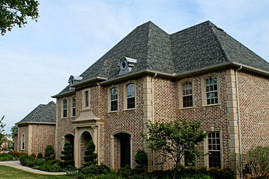Foto della facciata di una casa grande classica a due piani con rivestimento in mattoni