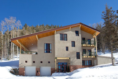 Diseño de fachada beige tradicional renovada grande de tres plantas con revestimiento de estuco