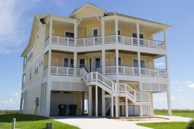 Inspiration for a large coastal yellow three-story concrete fiberboard gable roof remodel in Houston