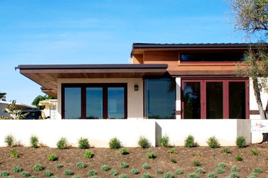 Foto de fachada beige actual de una planta con revestimientos combinados y tejado plano