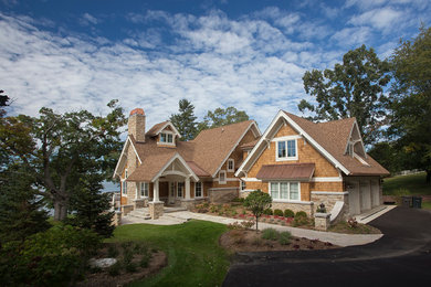 Example of a large mountain style brown two-story wood gable roof design in Milwaukee