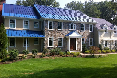 Example of a large classic brown two-story stone exterior home design in Other with a metal roof and a blue roof