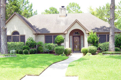 Photo of a medium sized and white traditional bungalow brick detached house in Houston with a hip roof and a shingle roof.
