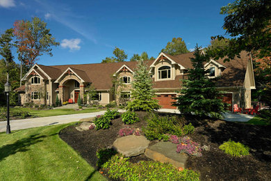 Inspiration for a large timeless beige three-story mixed siding exterior home remodel in Cleveland