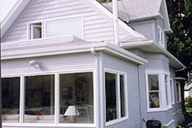 Modelo de fachada blanca de tamaño medio de dos plantas con revestimiento de madera