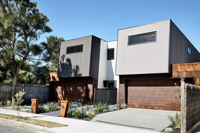 Modelo de fachada de casa pareada multicolor contemporánea de tamaño medio de dos plantas con revestimiento de metal, tejado plano y tejado de metal