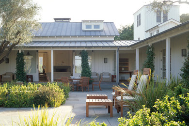 Imagen de fachada blanca de estilo de casa de campo de una planta con revestimiento de madera y tejado a dos aguas