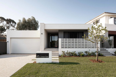 Стильный дизайн: одноэтажный, белый частный загородный дом среднего размера с комбинированной облицовкой, плоской крышей и металлической крышей - последний тренд