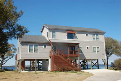 Cette photo montre une grande façade de maison grise bord de mer en bois à un étage avec un toit à deux pans et un toit en shingle.