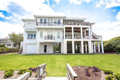 Idée de décoration pour une grande façade de maison blanche tradition à deux étages et plus avec un toit à quatre pans.