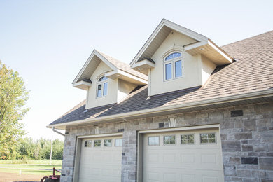 Example of a large classic beige two-story stone exterior home design in Ottawa with a hip roof